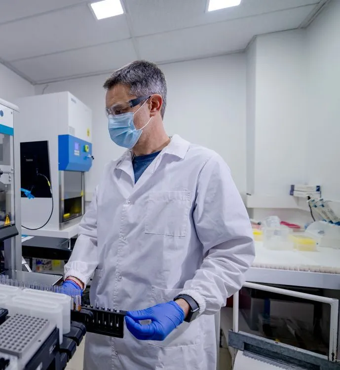 Profesional del laboratorio cargando muestras en un equipo de extracción